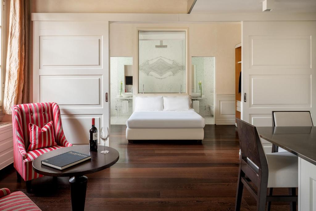 Sala de estar con cama, mesa y silla en Ricasoli Firenze Luxury Apartments | UNA Esperienze, en Florencia