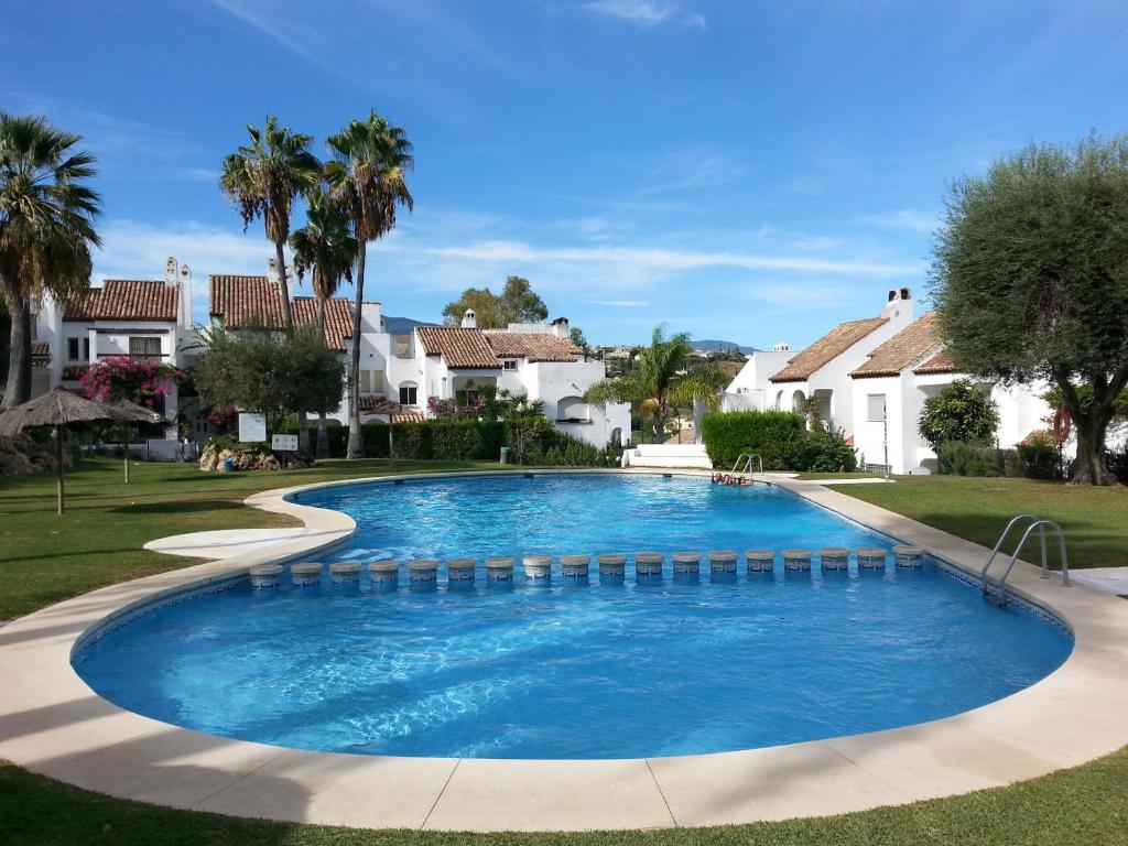 a swimming pool in a yard with houses at Casa Adosada Bel Andalus in Estepona