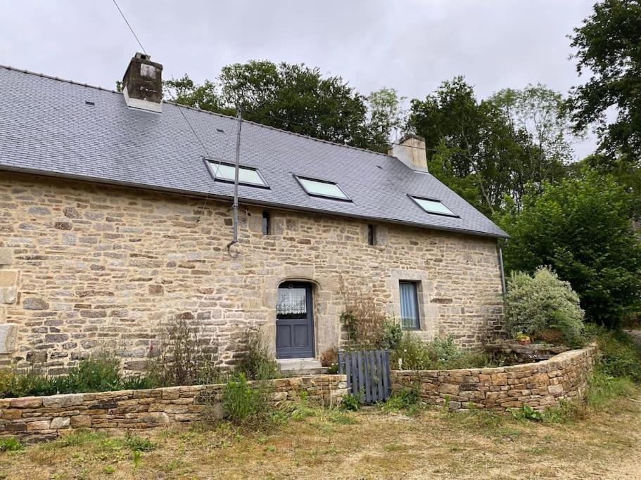 ein Backsteinhaus mit Fenstern und Schieferdach in der Unterkunft sejour paisible au coeur du morbihan in Pluvigner