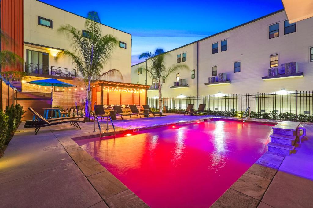 una piscina al centro di un edificio con luci rosse di Bienville Villas: Brand New 4BR a New Orleans