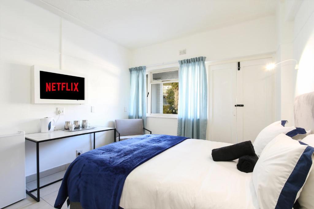a bedroom with a bed and a tv on a wall at Sea Point apartment in Cape Town