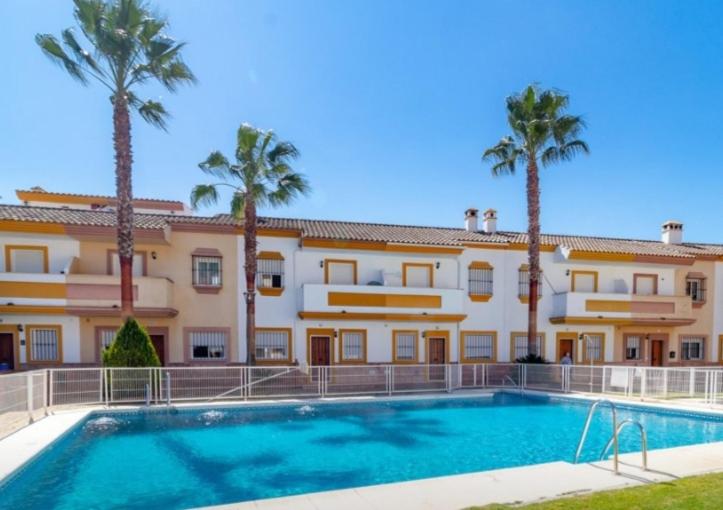 a large building with a swimming pool and palm trees at Casas de Benaojan 15 in Benaoján