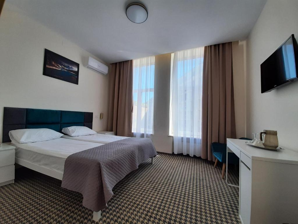 una camera d'albergo con letto e TV di Hotel Astoria City Center a Iaşi