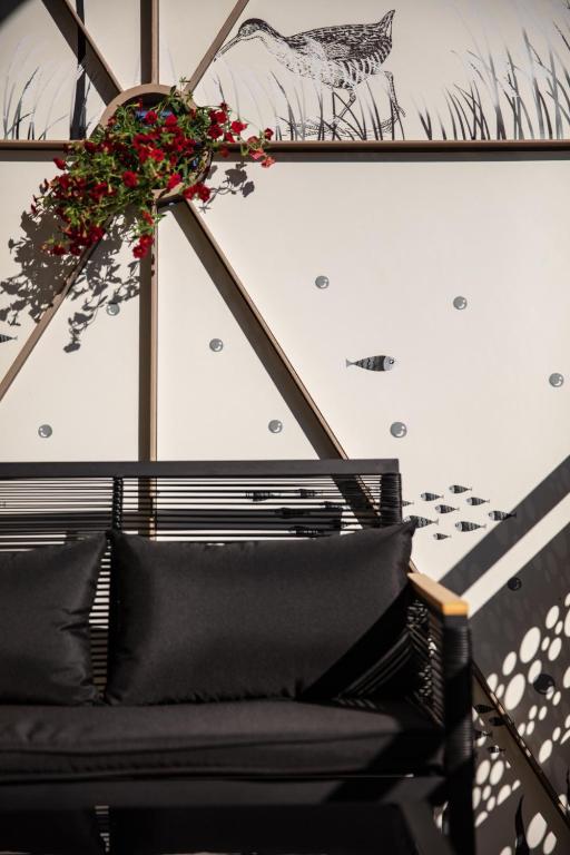a black couch with a flower arrangement on a wall at Pannonia Appartements 2 in Neusiedl am See