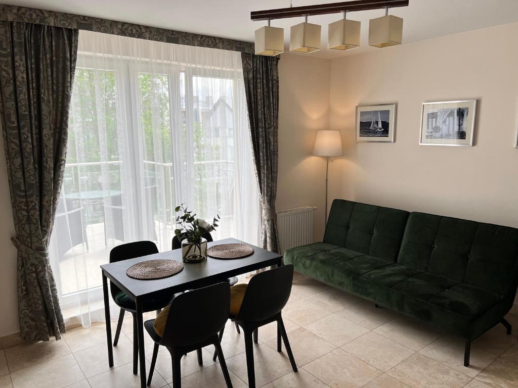 a living room with a green couch and a table at Apartament LAPIS Panorama Avangard in Świnoujście
