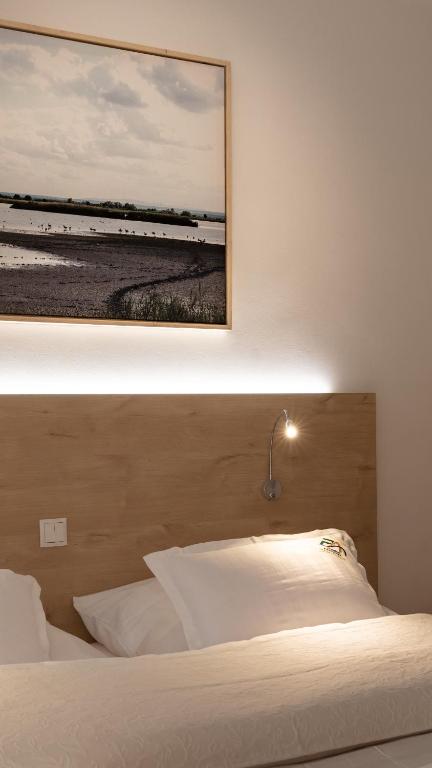 a bedroom with a bed with a picture on the wall at Pannonia Appartements 2 in Neusiedl am See