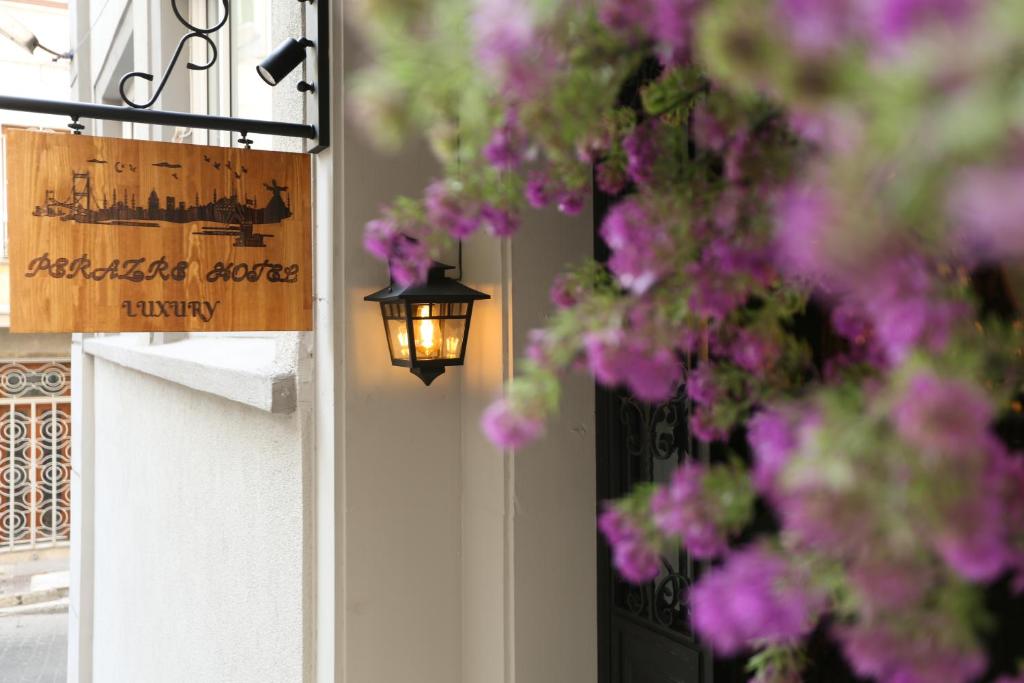 een bord op een deur met paarse bloemen en een lamp bij Perazre Hotel in Istanbul