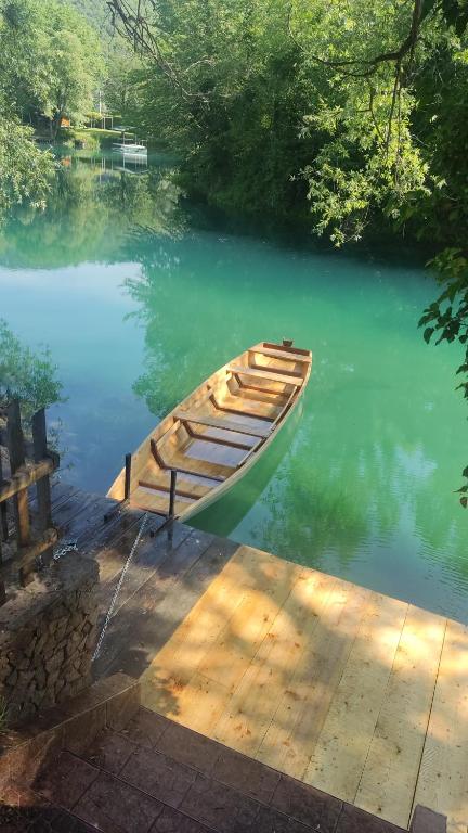 una barca seduta sull'acqua accanto a un molo di Kuca Delić a Račić