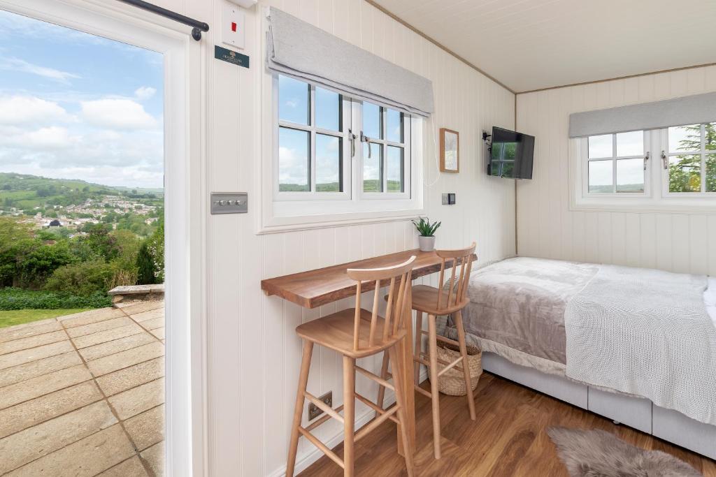 a bedroom with a bed and a desk next to a window at Secluded lodge with spectacular views and hot tub! in Bath