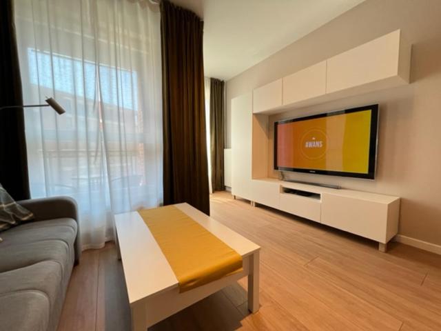 a living room with a couch and a flat screen tv at Apartament Bastion Wałowa Gdańsk in Gdańsk