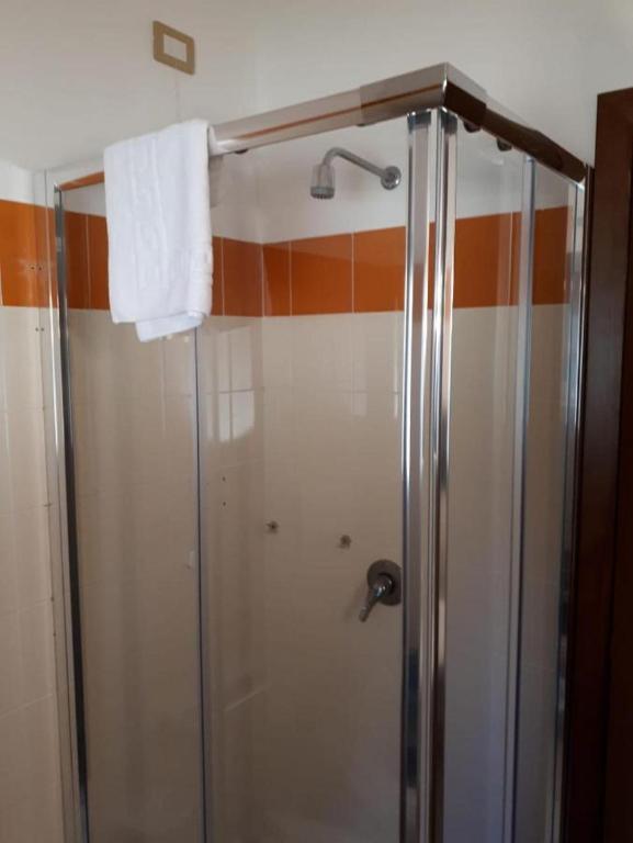 a shower stall in a bathroom with a towel at La Meta Sporting Rooms in Alghero