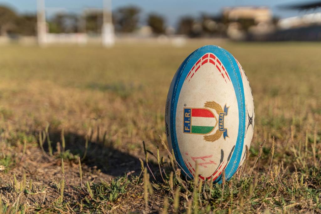 a rugby ball in the grass in a field at La Meta Sporting Rooms in Alghero