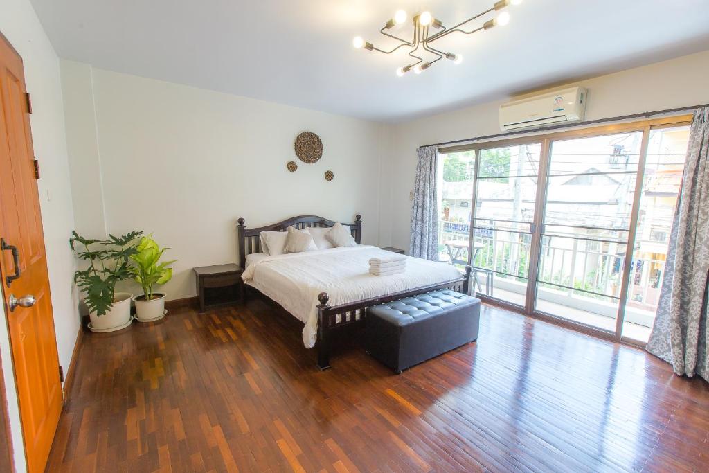 a bedroom with a bed and a large window at The Little Siri in Chiang Mai