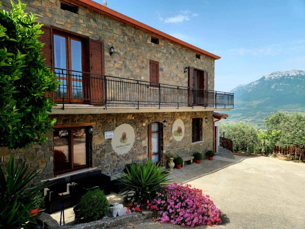 ein Gebäude mit einem Balkon und Blumen davor in der Unterkunft Pietra del Colle Agriturismo in Altavilla Silentina