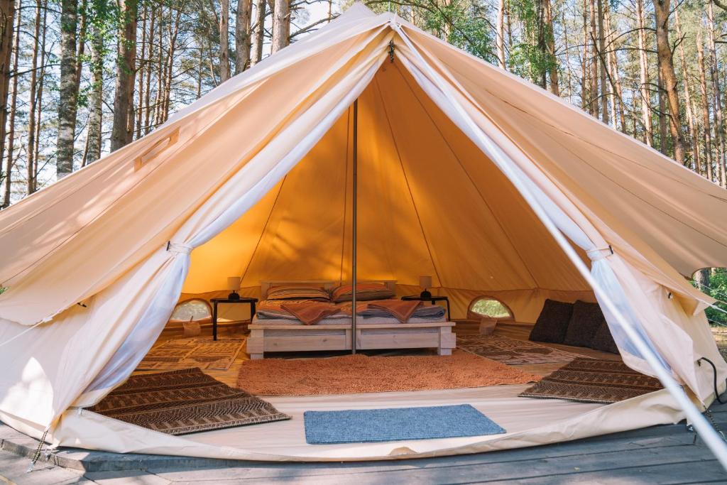 a large tent with a bed in the middle at Natur Camp Glamping Birštonas in Birštonas