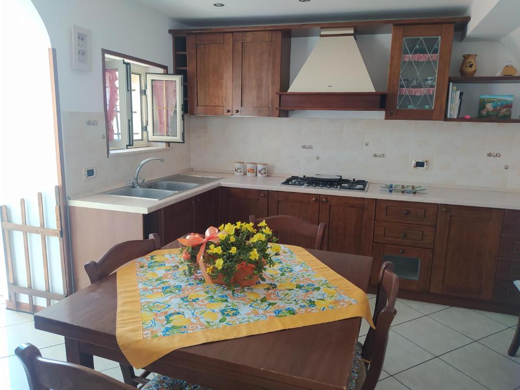 a kitchen with a table with flowers on it at Estìa Casa Vacanze in Scilla