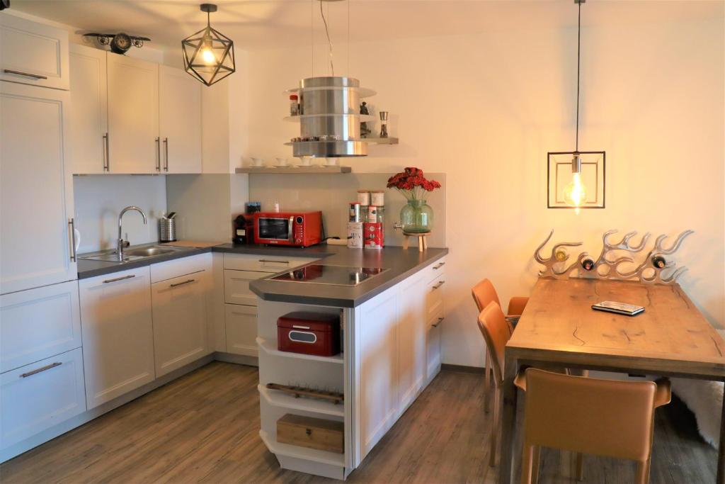 eine Küche mit einem Tisch und einem Esszimmer in der Unterkunft Neue Ferienwohnung mit Whirlpool und Sauna in der Residenz Grafenmatt inklusive HochschwarzwaldCard in Feldberg