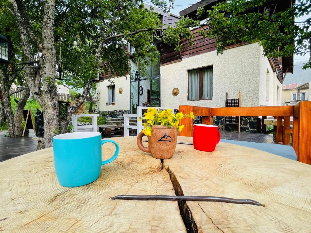 Ioska's House في ميستيا: طاولة خشبية مع كوبين و مزهرية بها ورد