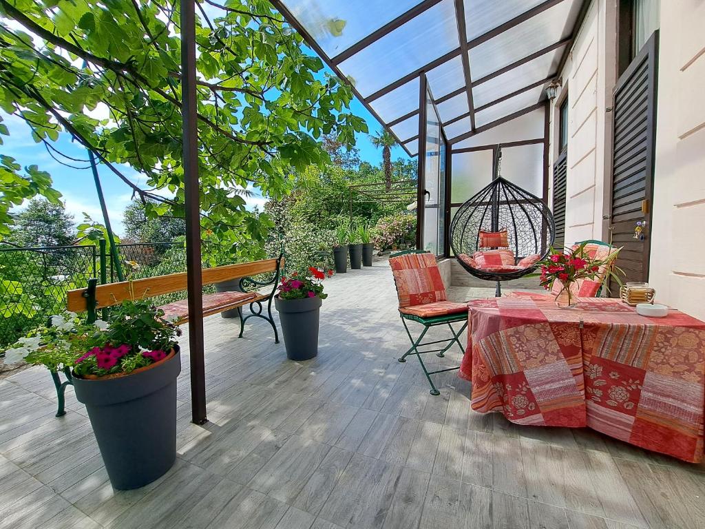 un patio con mesa, sillas y un columpio en Room soba u Opatiji Na Lipovici en Opatija