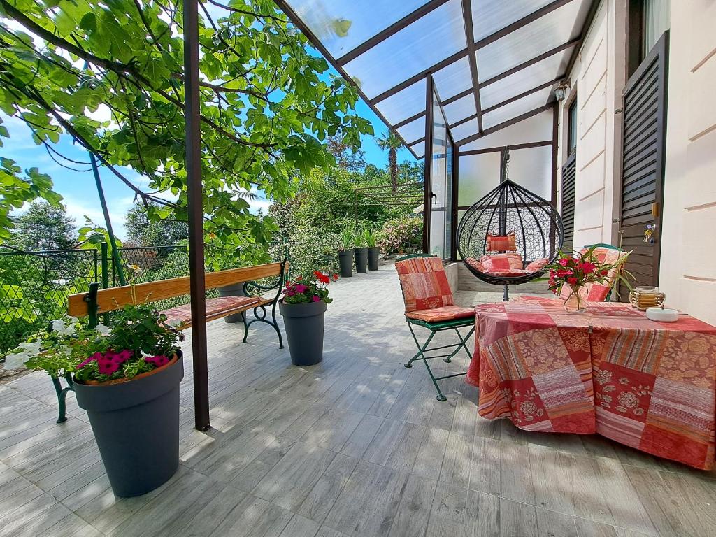 a patio with a table and chairs and a swing at Room soba u Opatiji Na Lipovici in Opatija