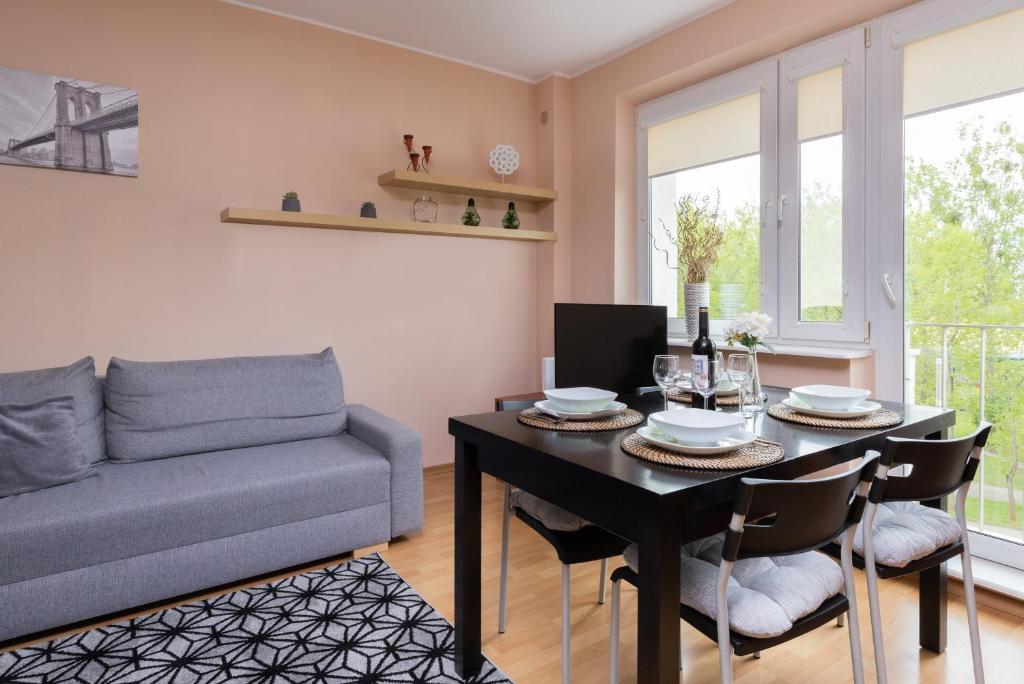 a living room with a table and a couch at Gdansk Zabianka Sztormowa Apartment with 1 Bedroom by Renters in Gdańsk
