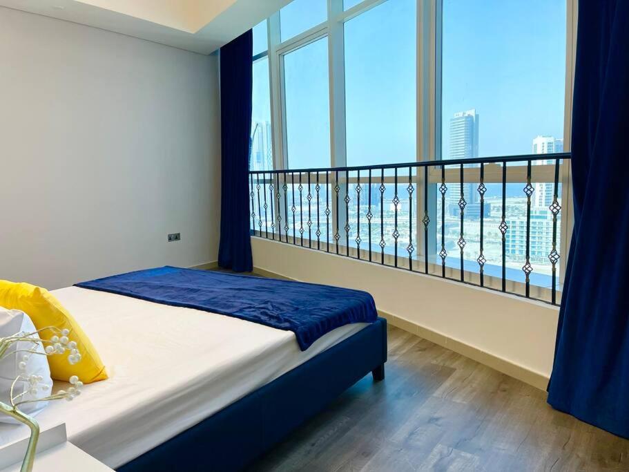 a bedroom with a balcony with a view of the city at Cozy Upgraded Residential Flat with sea, Mangrove, pool view - 1203 Not Hotel in Abu Dhabi