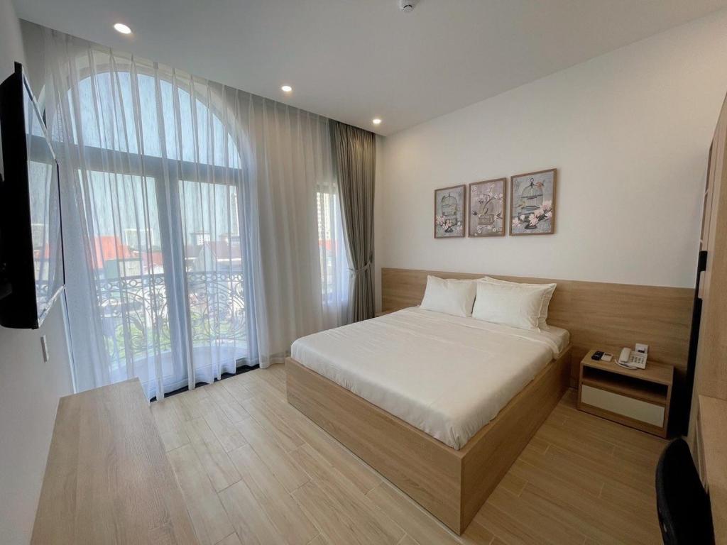 sypialnia z łóżkiem i dużym oknem w obiekcie Nhật Phương Hotel w mieście Hue