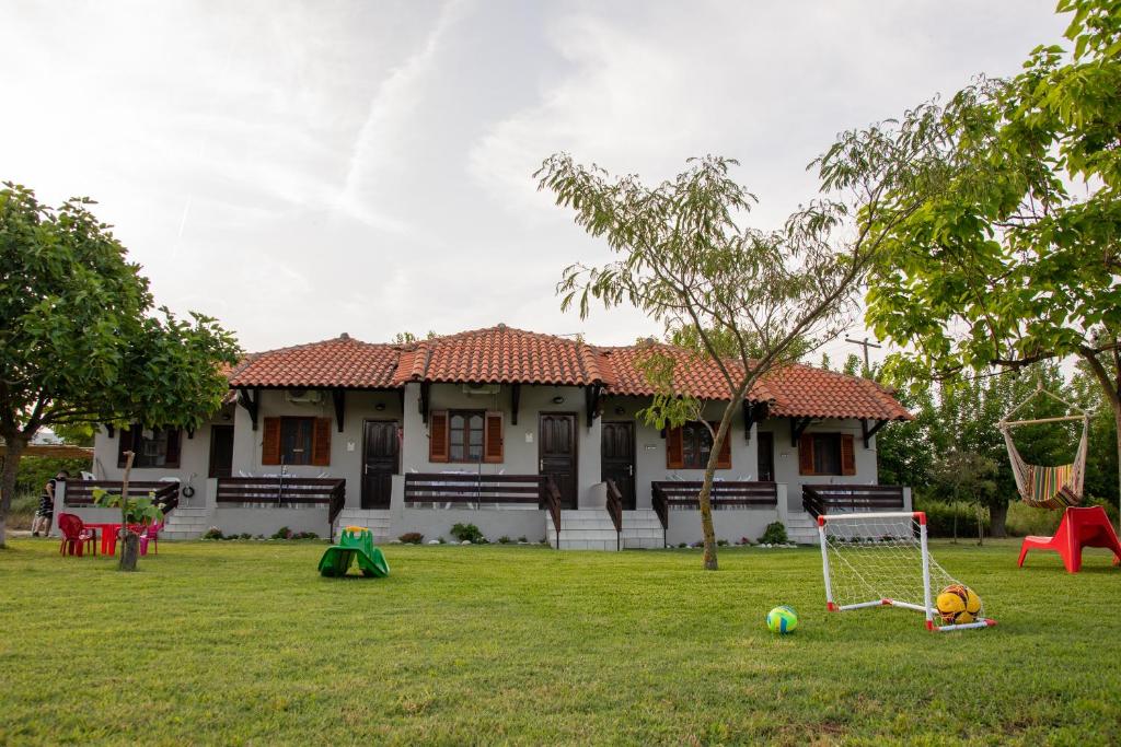 a house with a yard with playground equipment at melissi studios in Paralia Sikias