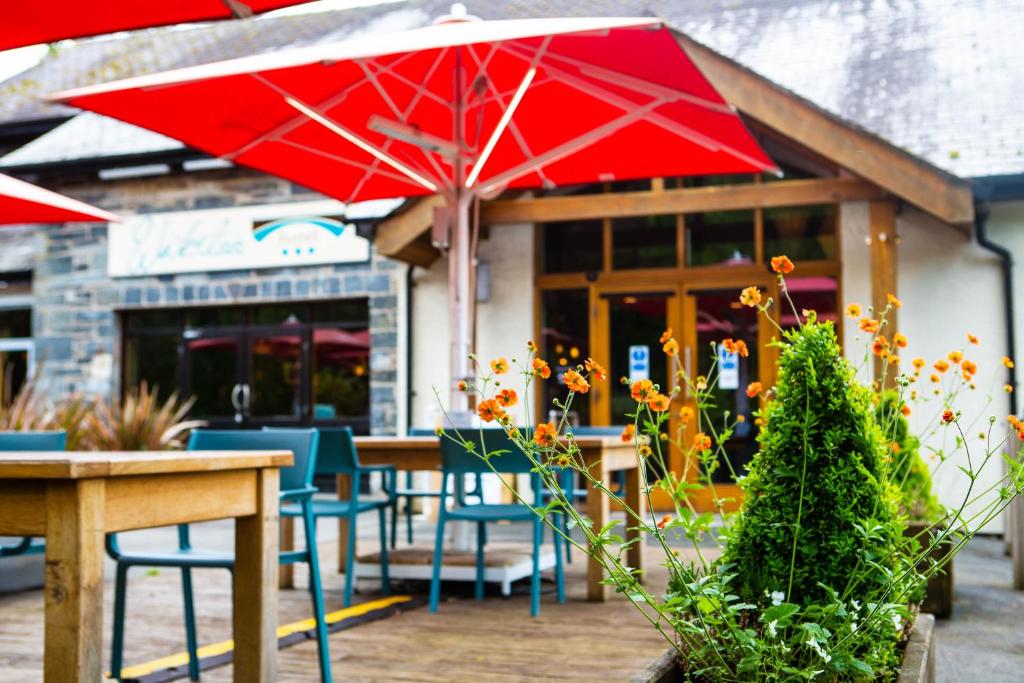 a restaurant with tables and chairs and a red umbrella at The Waterloo Hotel in Betws-y-coed