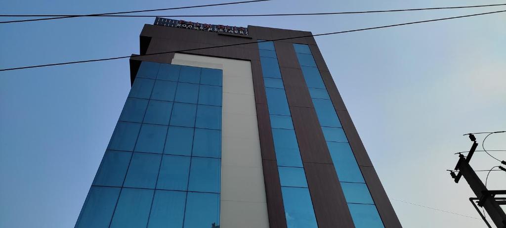 a tall building with a lot of windows at Hotel Palm Bliss International in Dānāpur