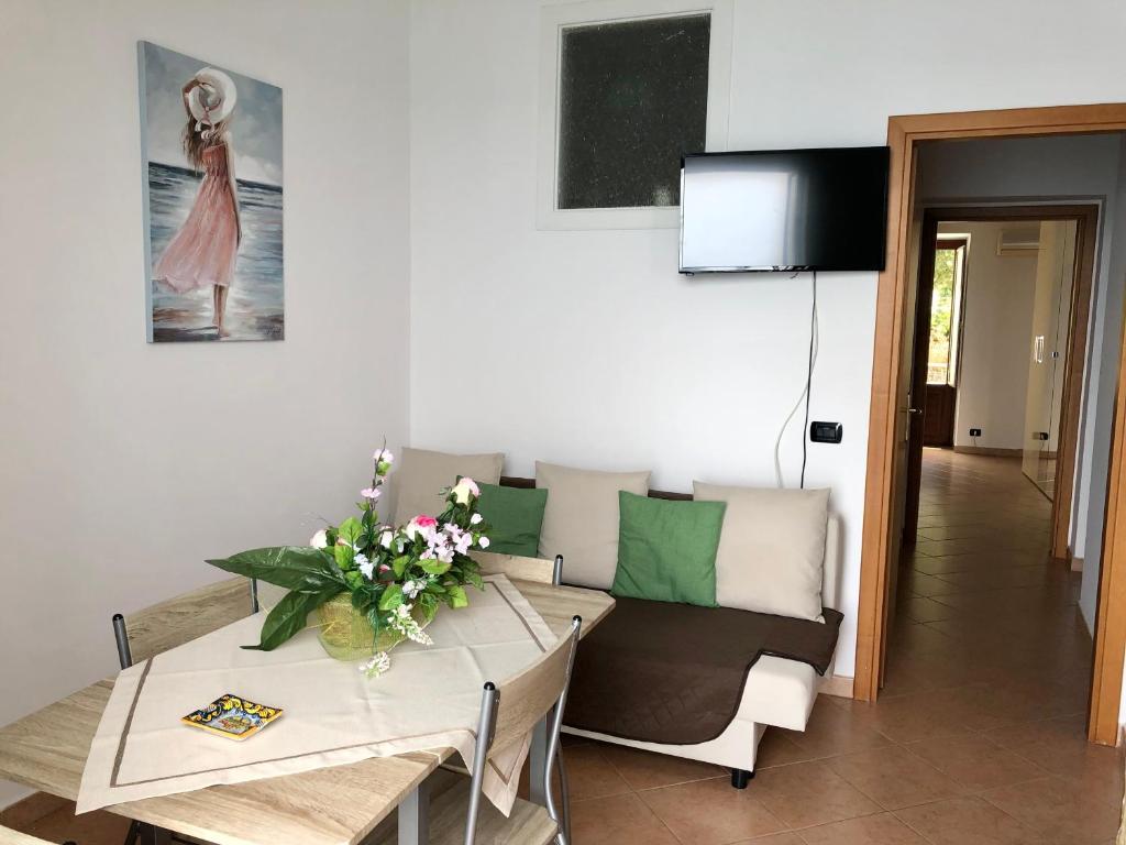 a living room with a table and a couch at La Casa Sulla Scogliera in Cefalù