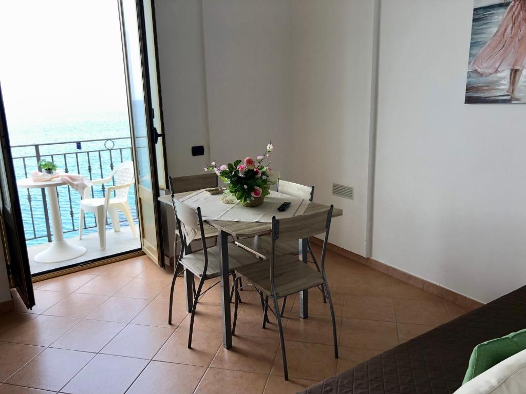 a dining room with a table and chairs and a balcony at La Casa Sulla Scogliera in Cefalù