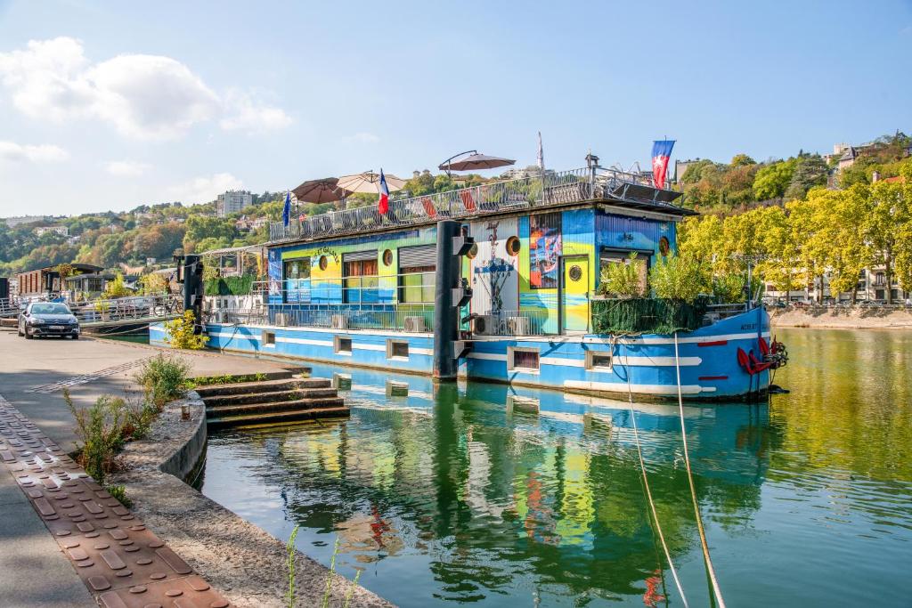 un barco atracado en un río junto a una carretera en Room in Studio - Mini Studio Peniche au coeur de Lyon, insolite et calme en Lyon