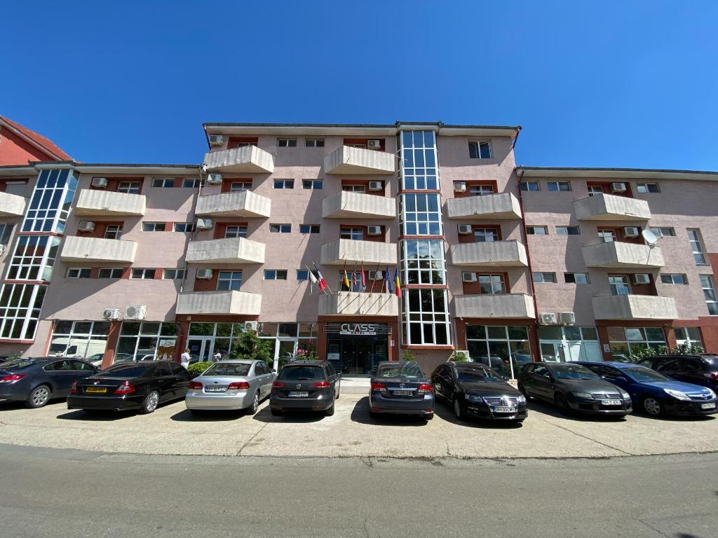 a parking lot in front of a large apartment building at Hotel Class in Oradea