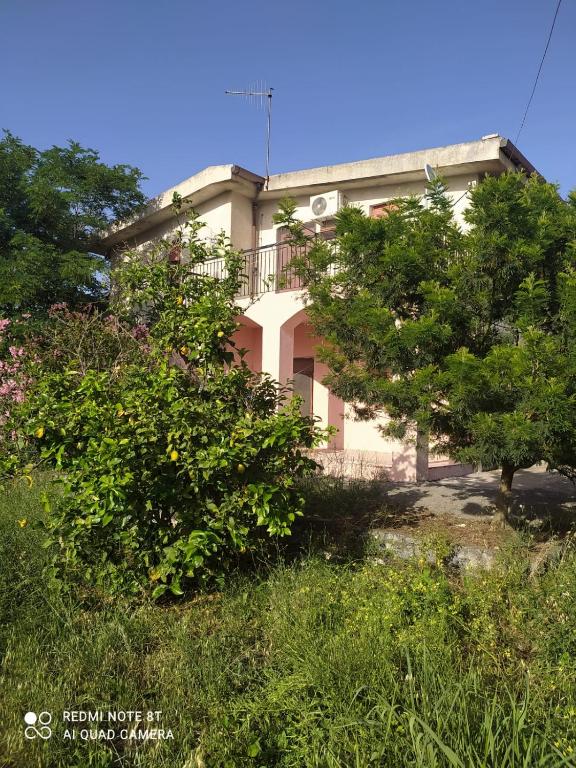 una casa grande con árboles delante de ella en La casa di Anna, en Grisolia