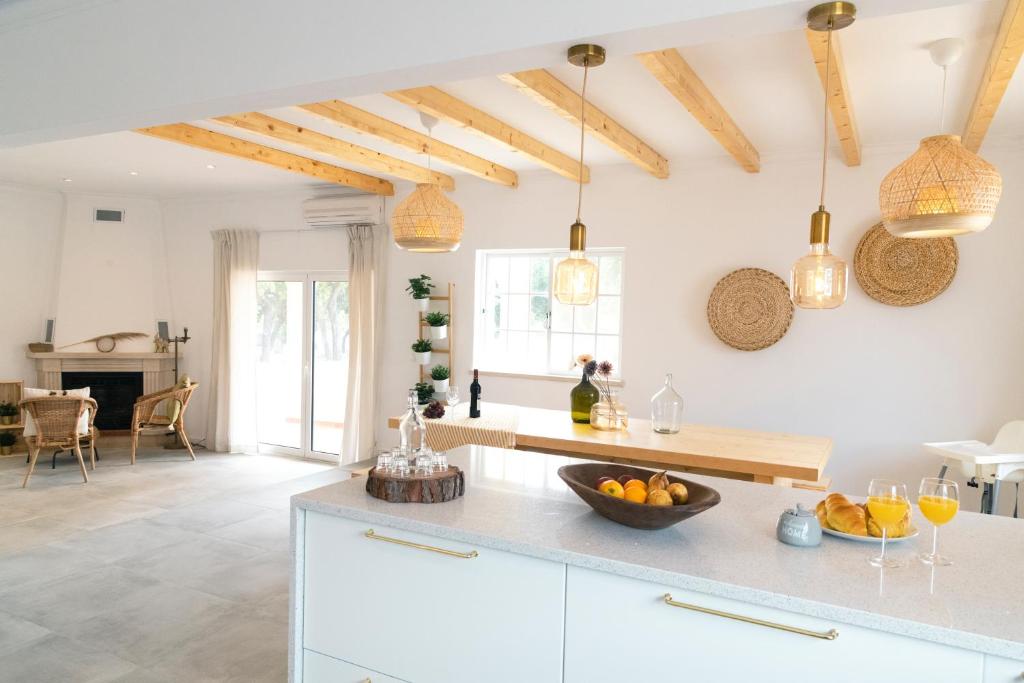 uma cozinha com armários brancos e tectos em madeira em Casa Portus - Turismo Rural em Faro