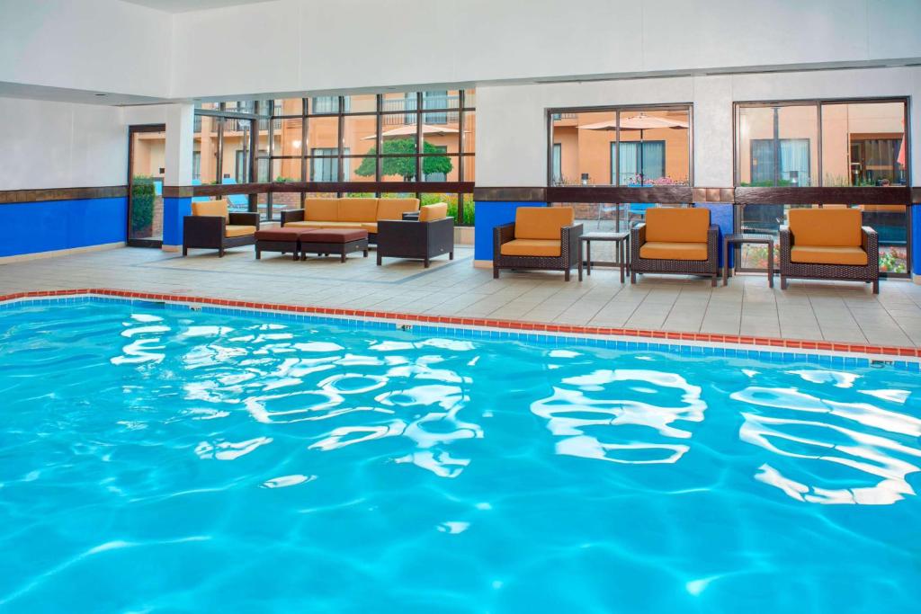 Sonesta Select Detroit Auburn Hills في أوبورن هيلز: حمام سباحة في الفندق مع الكراسي والطاولات