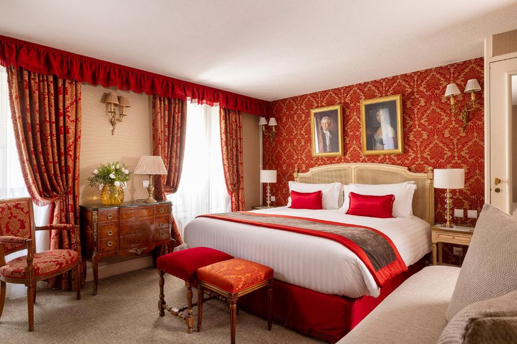 パリにあるホテル ドゥ セーヌの赤い壁紙の大型ベッド付きのベッドルーム1室