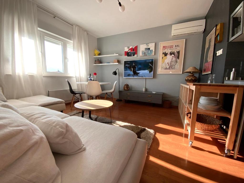 ein Wohnzimmer mit einem weißen Bett und einem Tisch in der Unterkunft Park view apartments in Kaštela