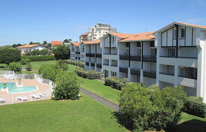 un grand immeuble avec une cour et une piscine dans l'établissement Studio cabine résidence 4 étoiles piscine tennis golf parking privé, à Bidart