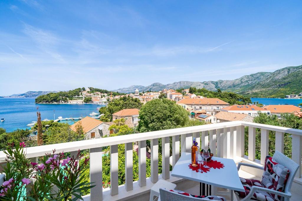 a balcony with a view of a town and the water at Apartments Mara & Petrunjela in Cavtat