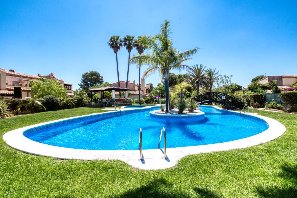 una gran piscina en un patio con palmeras en Villa Golfy 8 Golf Bonmont Terres Noves, en Bonmont Terres Noves