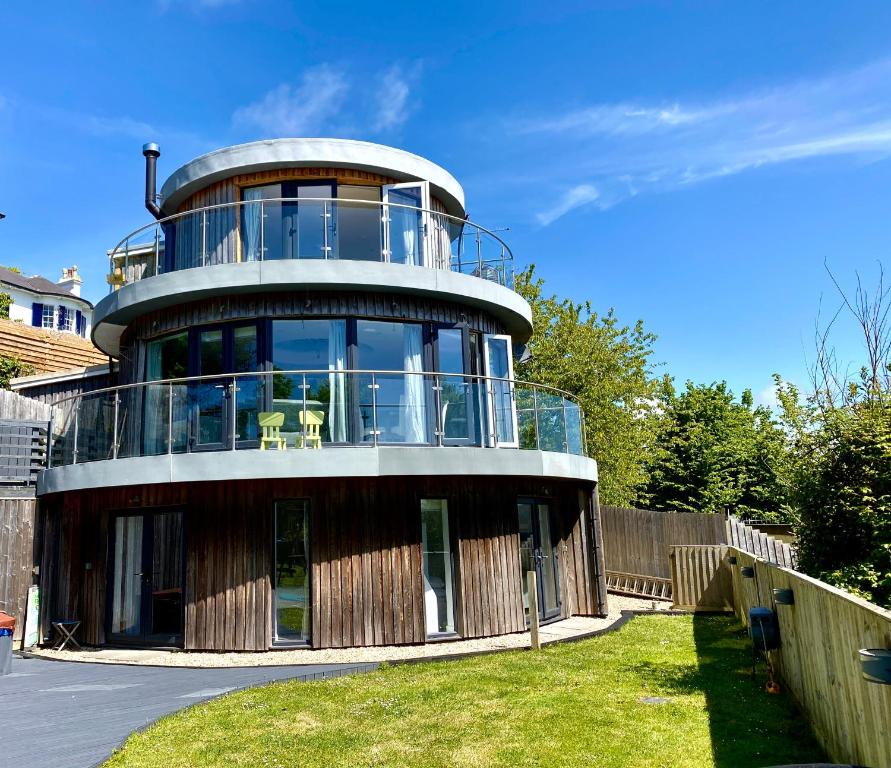 ein rundes Gebäude mit Balkon darüber in der Unterkunft One of the best properties in Lyme! Breathtaking views across the whole bay. 3 stories with 2 tier veranda around the property. Sleeps 6 in Lyme Regis