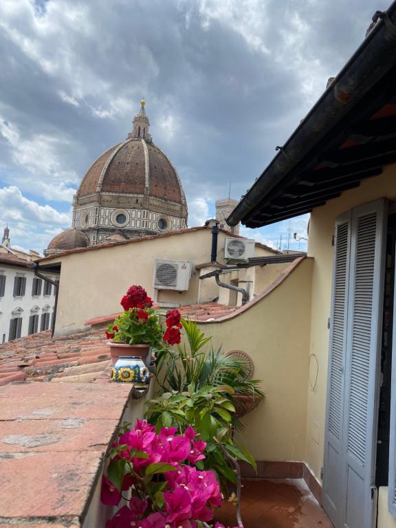 einen Balkon mit Blumen auf einem Gebäude mit einer Kuppel in der Unterkunft Al Campanile in Florenz