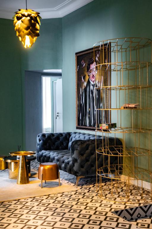 a living room with a black couch and a painting at W Urban Suites Budapest in Budapest