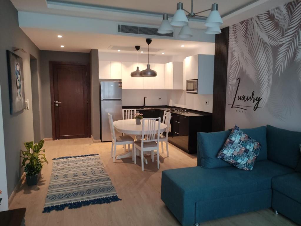 un salon avec un canapé bleu et une cuisine dans l'établissement Luxury Stay, à Sheikh Zayed