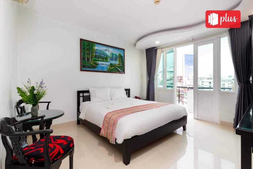 a bedroom with a bed and a table and a window at Saigon Pink Hotel in Ho Chi Minh City