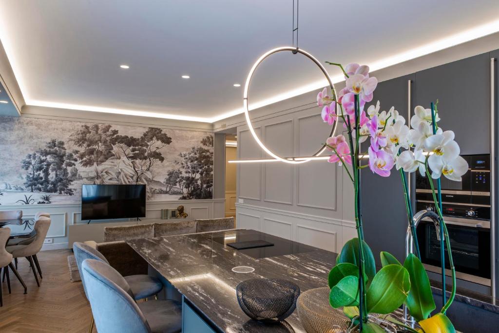 salon ze stołem i wazą kwiatów w obiekcie Villa Vitae - Alba Pompeia - Luxury apartment w Albie