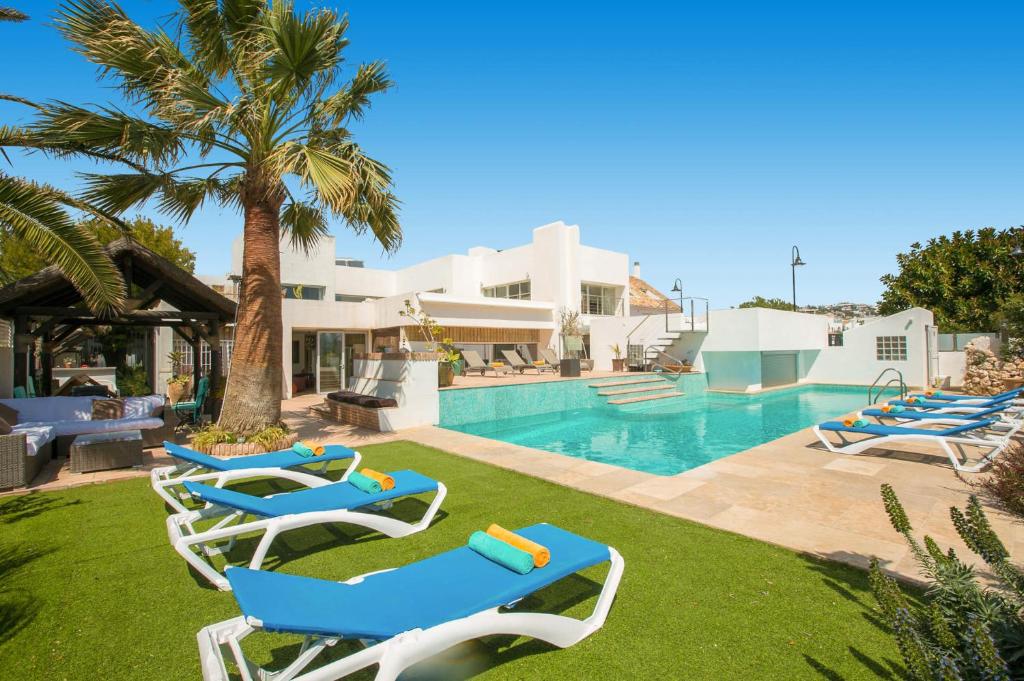 a group of lounge chairs by a swimming pool at Villa La Cala Playa by Villa Plus in La Cala de Mijas