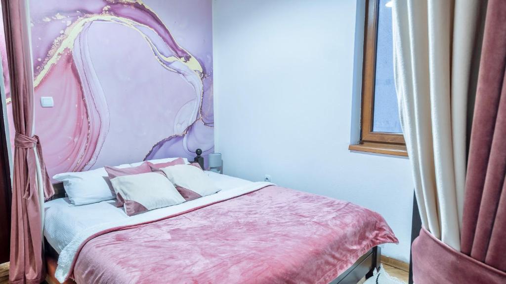 a bedroom with a canopy bed with pillows on it at Apartman Monti Vlašić in Vlasic